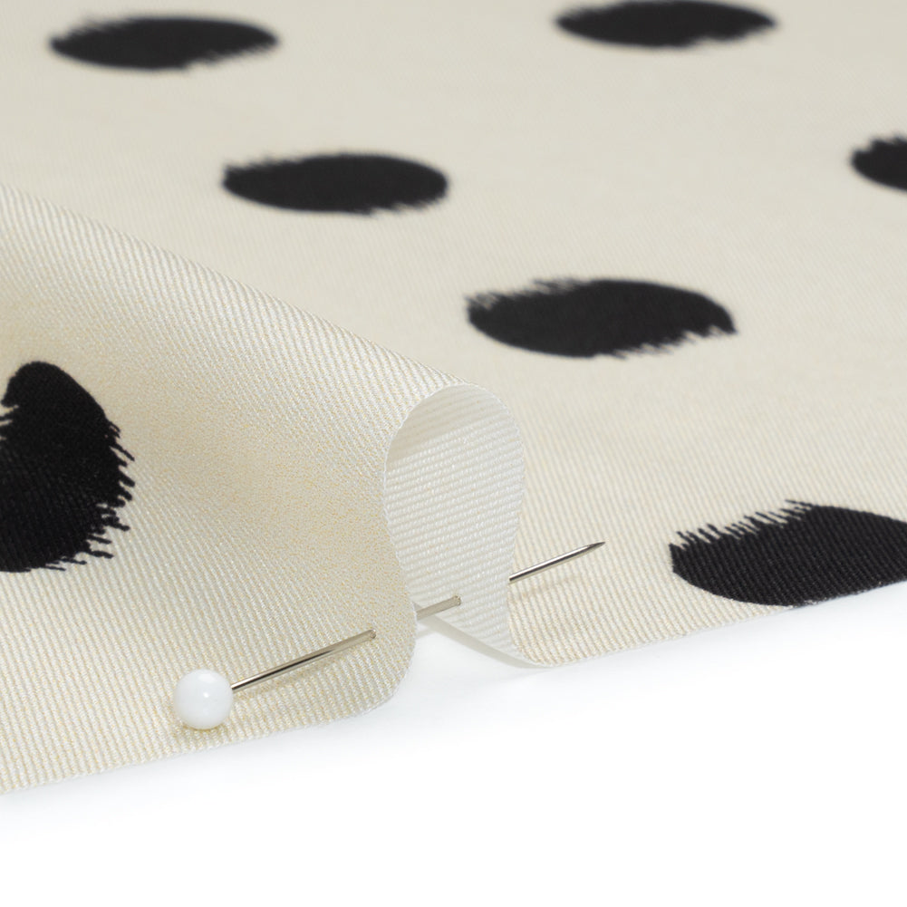 Fabric, polyester twill, black brushed polka dots on ivory background