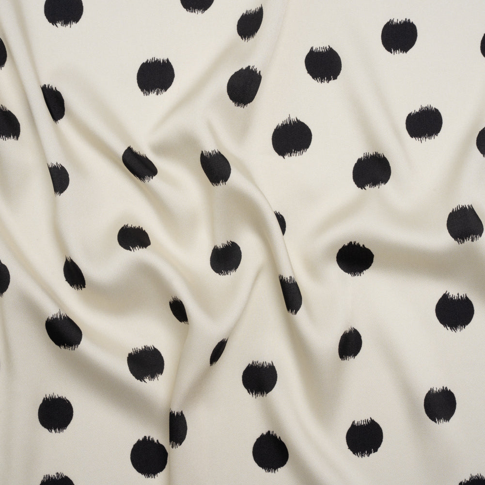 Fabric, polyester twill, black brushed polka dots on ivory background